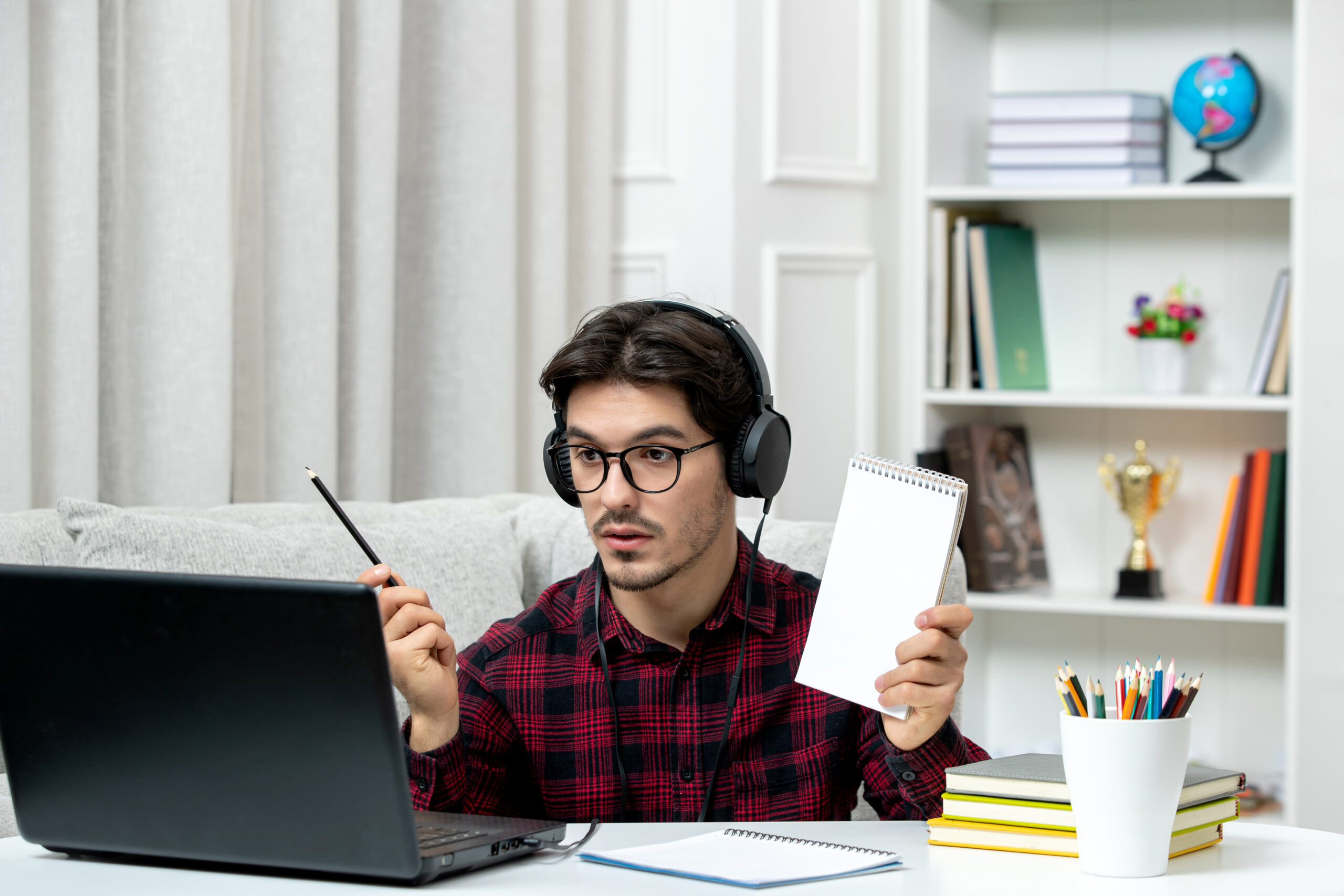 student-online-cute-guy-checked-shirt-with-glasses-studying-computer-holding-pen-notebook